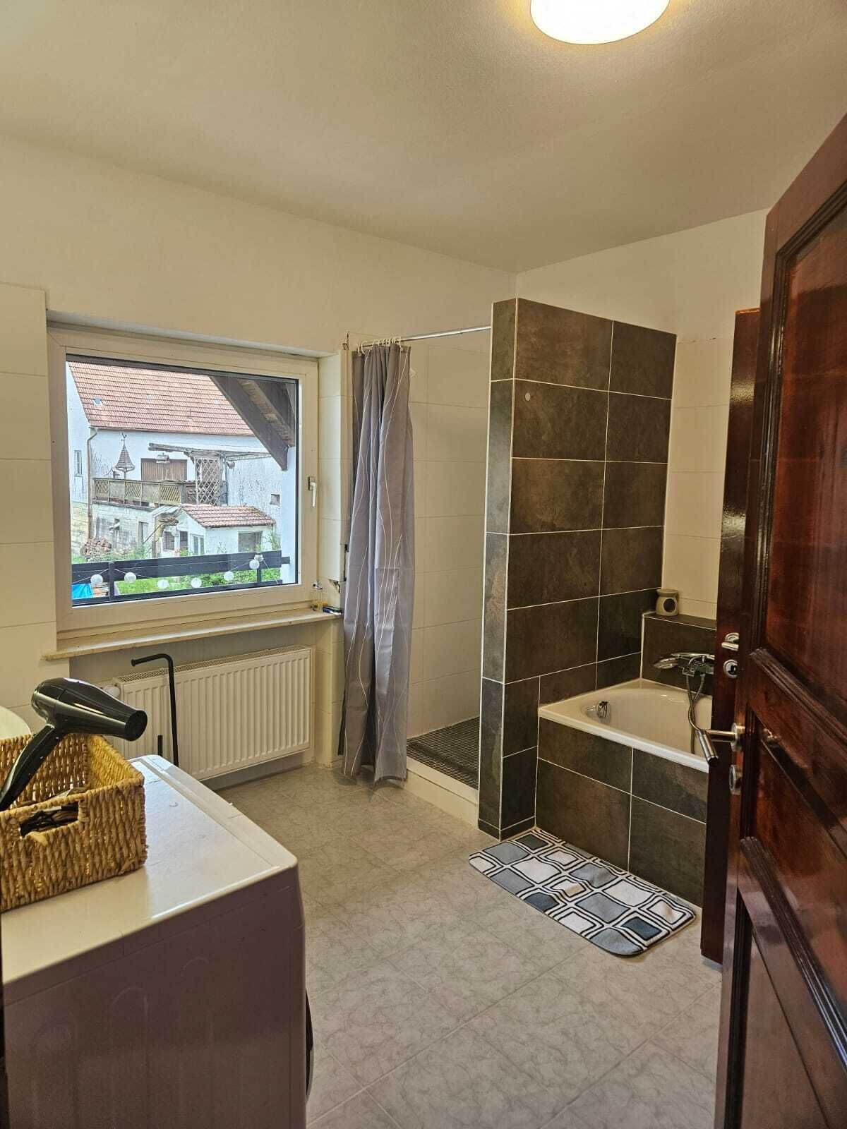A bathroom with a window, a shower, and a bathtub.