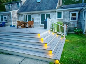 A wooden deck with steps leading to a house. - Barnstable Breeze with Seasonal Pool and Hot tub (West Barnstable)