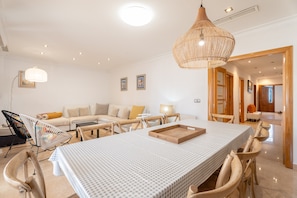 A dining area with a table set for four, surrounded by wooden chairs.