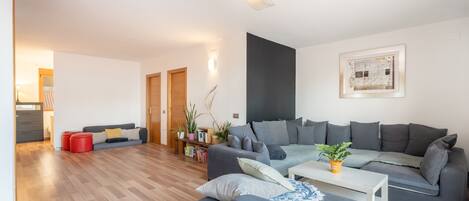Een moderne woonkamer met een modulaire bank, een salontafel en een boekenplank.
