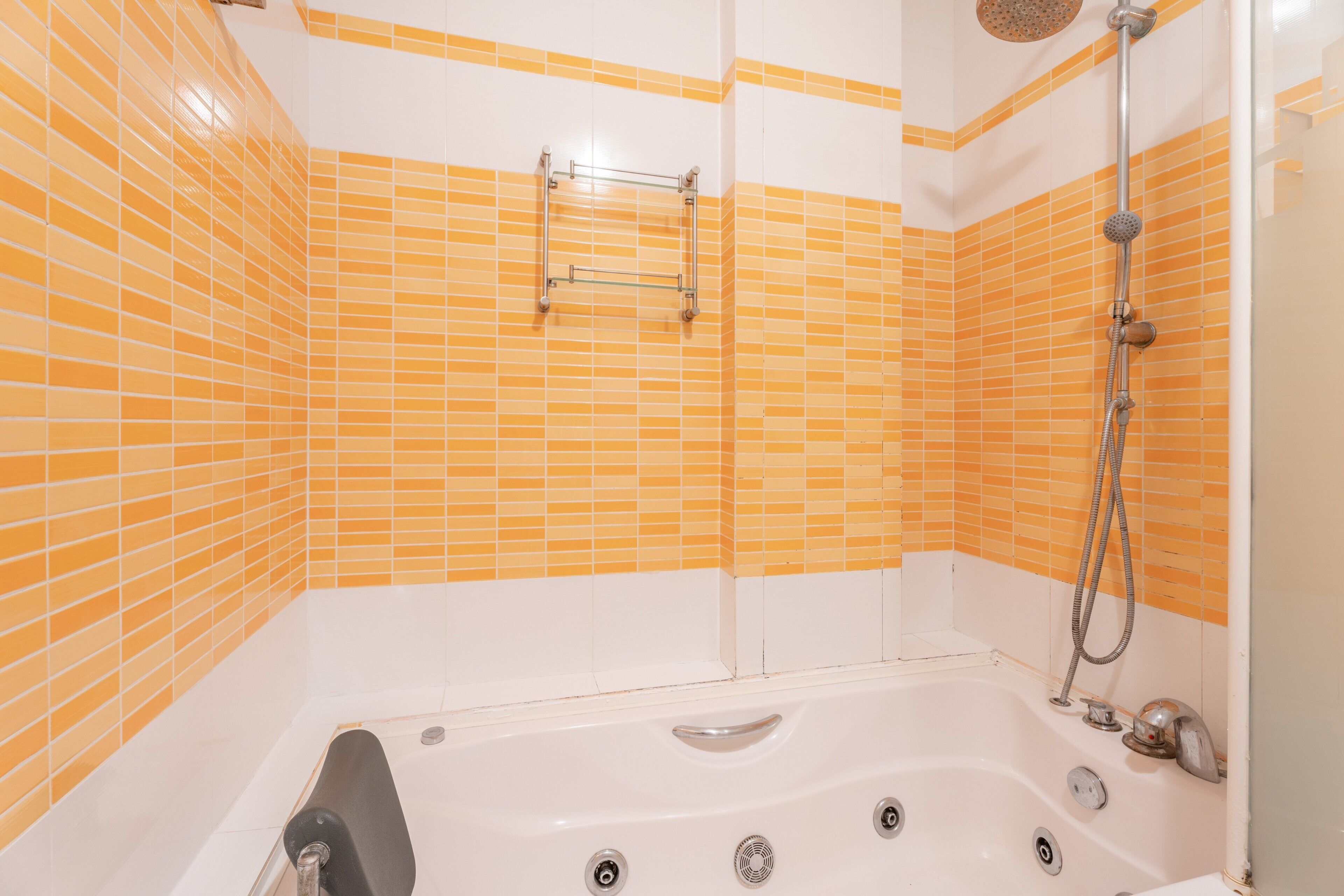 A bathroom with a bathtub, a shower, and a towel rack.