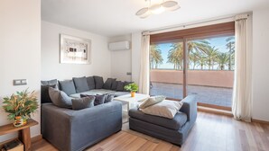 Una sala moderna con un sofá gris, una mesita de centro y una planta en maceta.