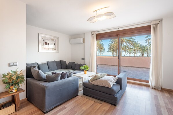 A modern living room with a grey sofa set, a small coffee table, and a potted plant.