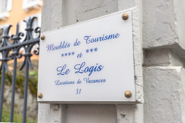 A sign with text indicating 'Meubles de Tourisme et Le Logis Locations de Vacances 31.'