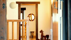 A wooden staircase leading to a room with a rocking horse, a circular mirror, and a small table.