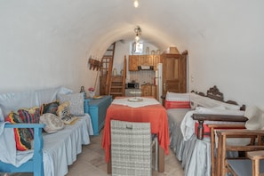 A cozy, compact living space with a kitchen area, a dining table, and a sofa.