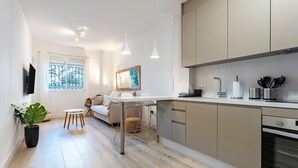 Eine moderne Küche mit Essbereich, einem großen Fenster und einer Topfpflanze.
