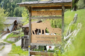 A wooden sign with 'FRAGGES' and 'FERIENWÜHNUNGEN APARTMENTI' indicating a lodging area.