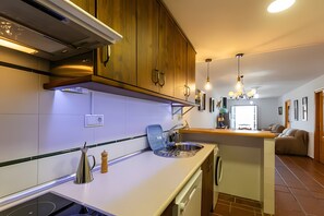 Une cuisine moderne avec des meubles en bois, un lave-vaisselle encastré et un îlot central doté d’un évier.