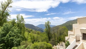Blick auf eine Hügellandschaft mit einem Gebäude, das eine Treppe und einen Balkon zeigt.