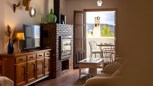 Ein Wohnzimmer mit Kamin, Fernseher und Essbereich mit Stühlen.