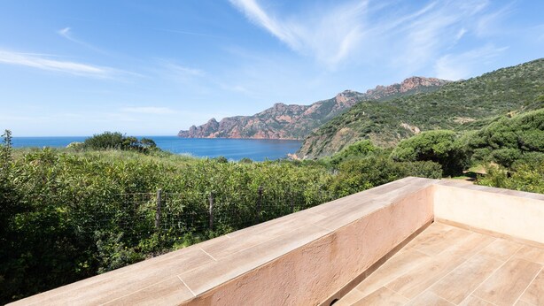 A terrace with a view of the sea and mountains.