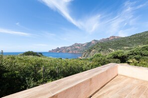 Eine Terrasse mit Blick auf das Meer und die Berge.