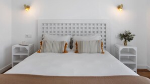 A neatly made bed with a white headboard, two bedside tables with lamps, and a small plant on one table. - Studio 'Quinta Dos Raposos - Villa Terra' with Shared Pool, Terrace and Wi-Fi (Nazaré)