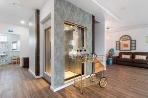 Uma sala de estar moderna com divisória de vidro, carrinho de café e sofá.