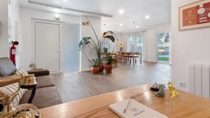 A hotel lobby with a wooden reception desk, a vintage telephone, potted plants, a dining area, and a fire extinguisher. - Country House "Quinta dos Raposos" - Villa Mar (Nazaré)