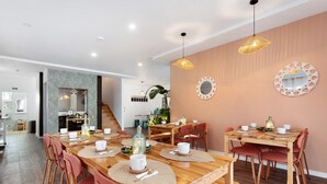 A modern dining area with wooden tables, red chairs, and a kitchen in the background. - Country House "Quinta dos Raposos" - Villa Mar (Nazaré)