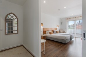 Une chambre à coucher avec un grand lit, une petite table et un miroir au mur.