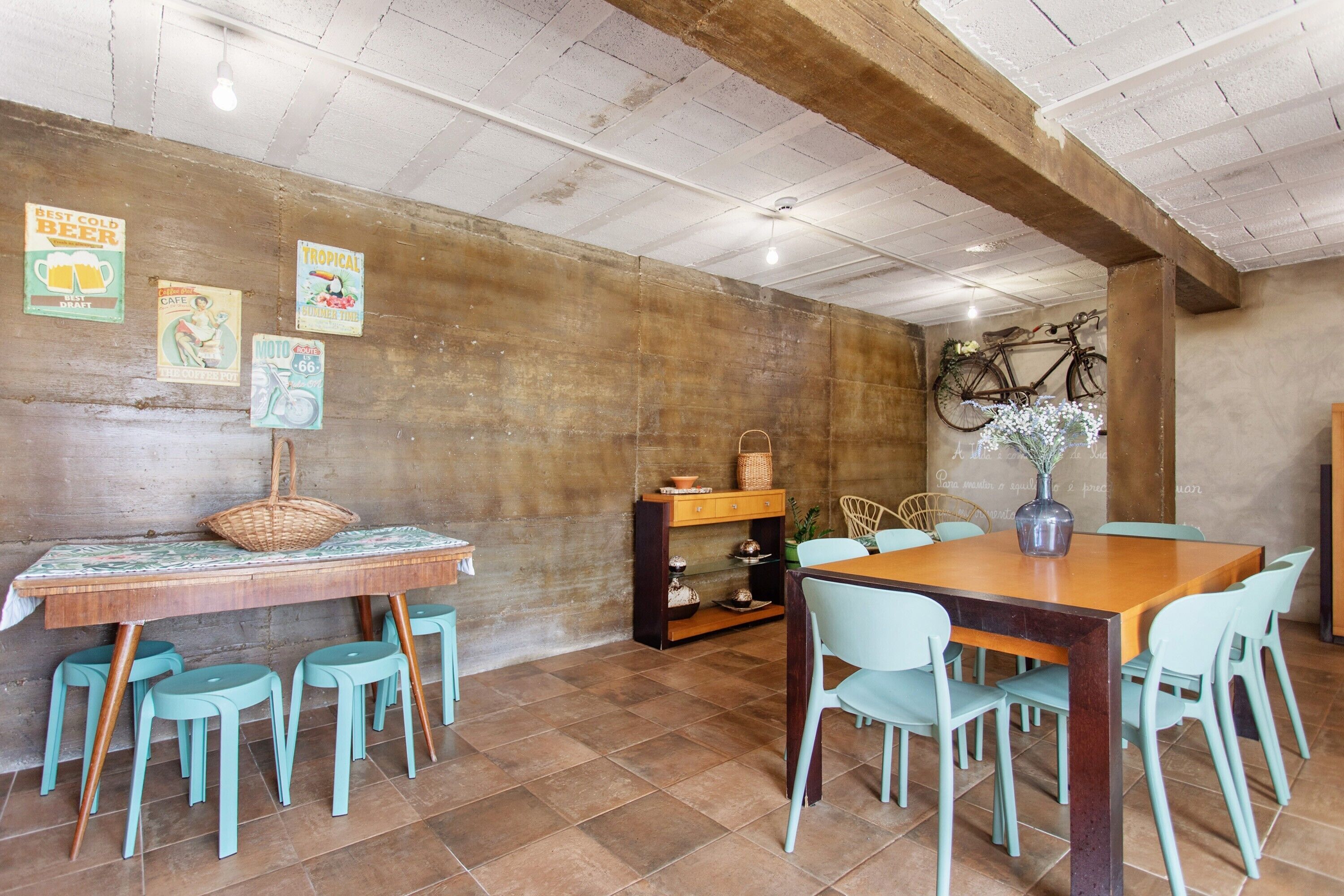 A dining area with a wooden table, light blue chairs, and a bicycle mounted on the wall.