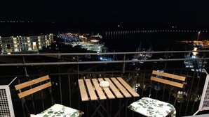 A balcony with two wooden chairs and a table, overlooking a marina with boats and buildings. - Dimora dei Naviganti - 15 Min from Amalfi Coast Sea View with Jacuzzi (Salerno)