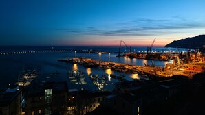 A harbor at dusk with boats docked, cranes, and a distant mountain. - Dimora dei Naviganti - 15 Min from Amalfi Coast Sea View with Jacuzzi (Salerno)