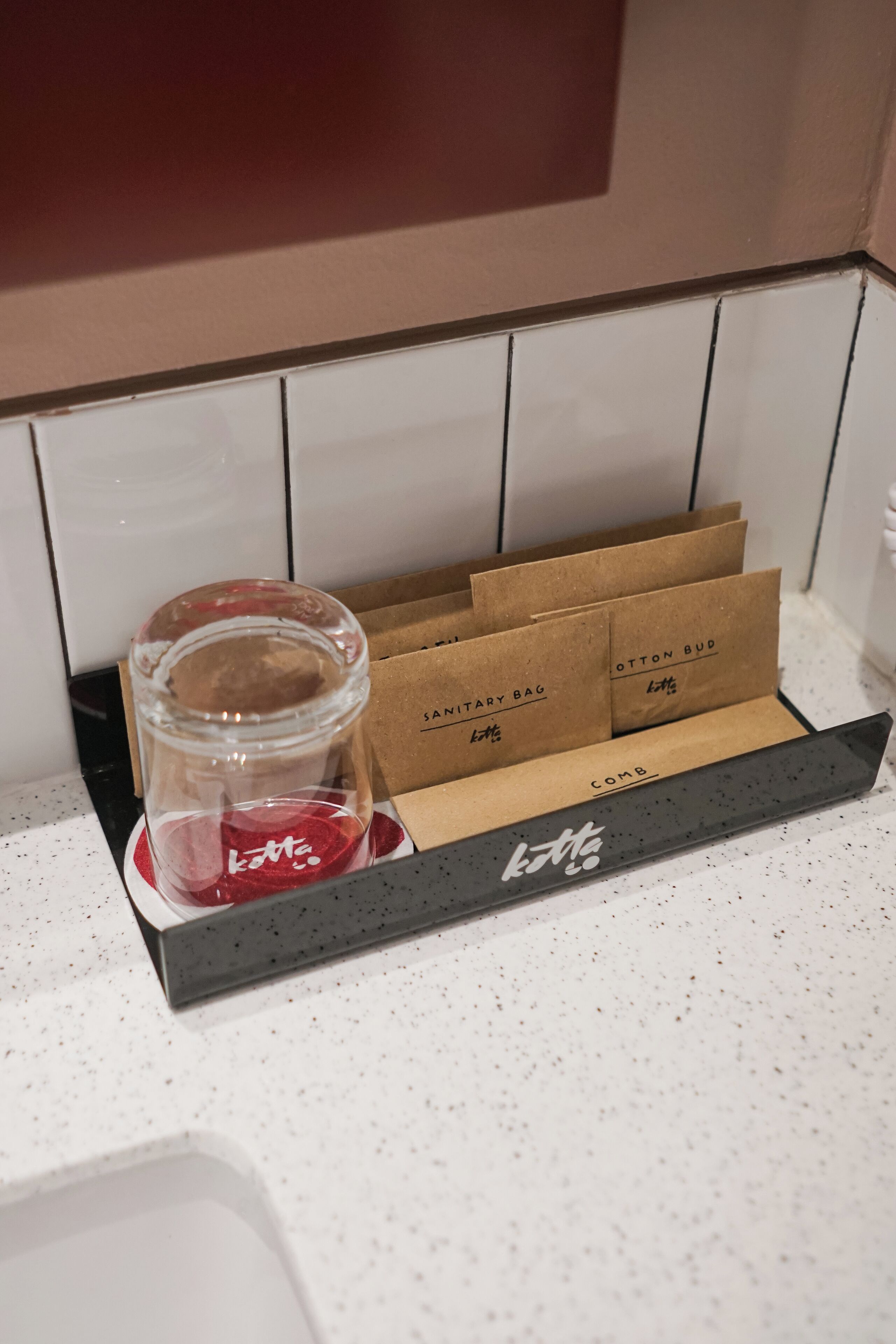 A kitchen counter with a spice rack holding several spice jars and a glass container with a red substance.