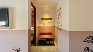 A narrow hallway with a bench, a coat rack, and a wall-mounted artwork. - Kotta GO Hotel Tegal (Tegal)