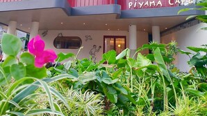 A building with a modern design, featuring a prominent vertical structure with a sign that reads "KOTTA" and "PIYAMA CAFE" at the bottom. - Kotta GO Hotel Tegal (Tegal)