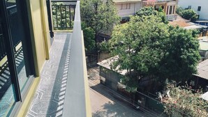 A view from a window overlooking a residential area with a paved walkway and a fence. - Nha Nghi Thanh Binh 2 (Vinh Hung)