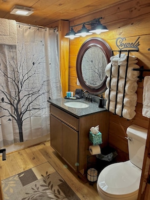 A bathroom with a wooden interior, a sink, a toilet, and a towel rack.