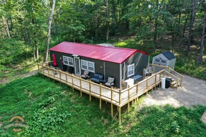 A cabin with a red roof, a deck, and outdoor seating. - Peaceful, Private Hot tub and, close to attraction (Logan)