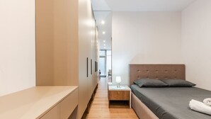 A modern bedroom with a bed, bedside table, and a wardrobe.