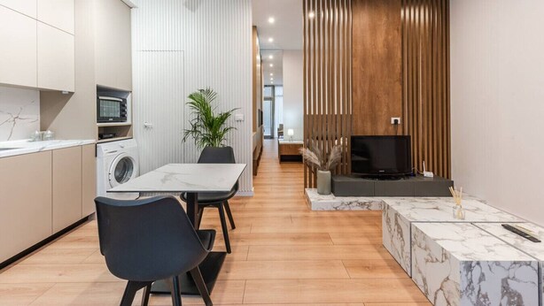 A modern apartment with a kitchen, dining area, and living room.