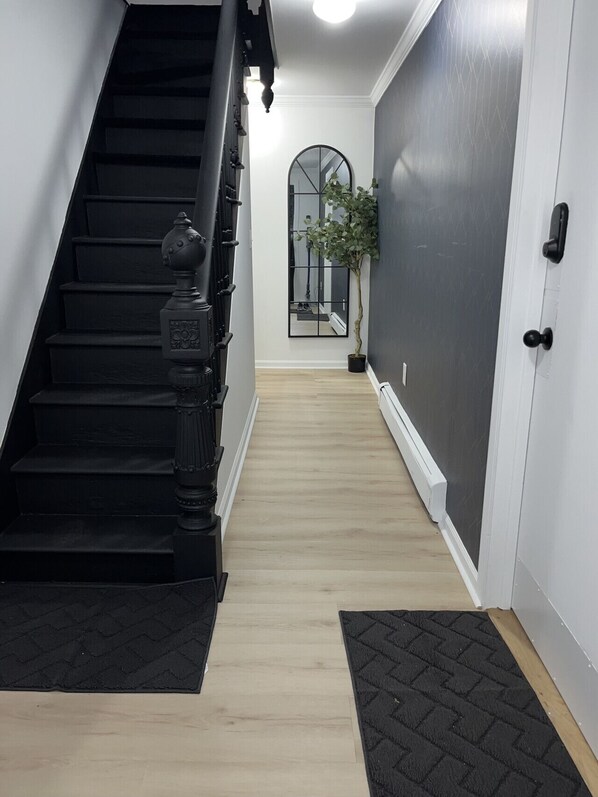 A staircase leading to a landing with a mirror and a potted plant.