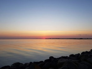 A calm body of water with a rocky shoreline in the foreground.