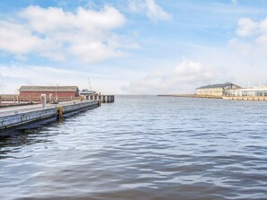 Una propiedad frente al agua con un muelle, un edificio grande y una estructura más pequeña.