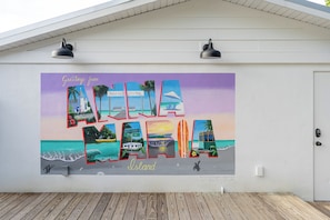 A wall mural with various travel scenes and the word "Island" at the bottom.
