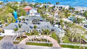 A coastal residential area with houses, a swimming pool, and a view of the ocean. - Unique Canal Home in The Best Location (Holmes Beach)