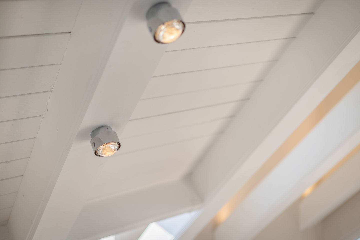 Un soffitto con due faretti incassati e una forma inclinata.