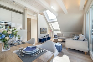 A modern loft apartment with a dining area, a living room, and a kitchen. - Dünenloft - Relax and enjoy in the Dünenloft: your perfect vacation apartment on the (Rantum)