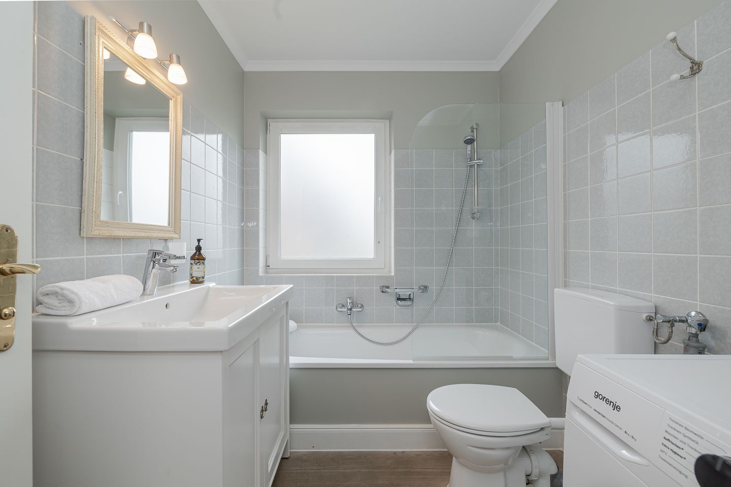 Et moderne badeværelse med vaskebord, toilet og badekar.