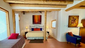 Quarto com uma cama, duas mesas de cabeceira, uma cadeira e um quadro na parede.