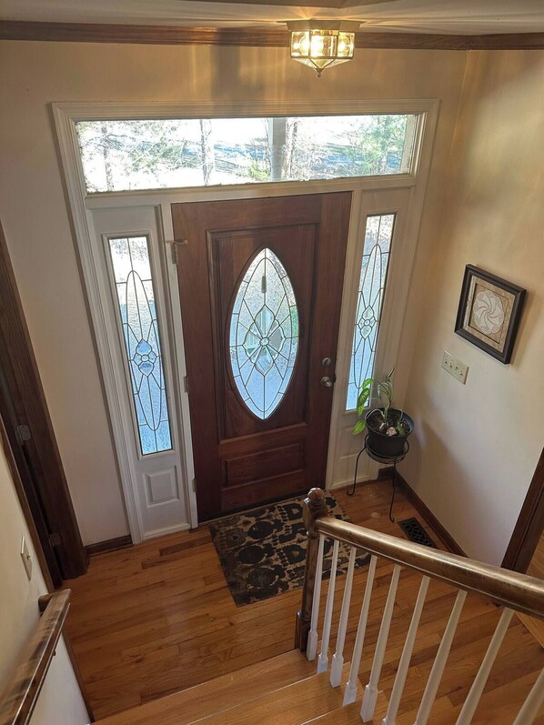 A wooden staircase leading to a door with a stained glass window.