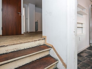 A staircase leading to a room with a radiator and a door.