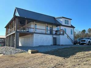 A two-story house with a balcony, a covered porch, and a garage. - RIVERFRONT  NEW 4-bedroom house with WiFi and AC in Calico Rock (Calico Rock)