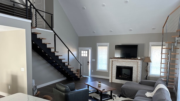 A spacious living room with a fireplace, a staircase, and a television. - RIVERFRONT  NEW 4-bedroom house with WiFi and AC in Calico Rock (Calico Rock)