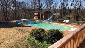 A backyard with a swimming pool, a slide, and a wooden deck. - Charming 1-bedroom house with WiFi and AC in peaceful Mount Pleasant (Mount Pleasant)