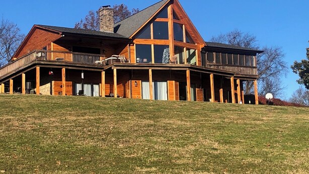 A large, two-story log cabin with a wrap-around porch and multiple windows. - Charming 1-bedroom house with WiFi and AC in peaceful Mount Pleasant (Mount Pleasant)