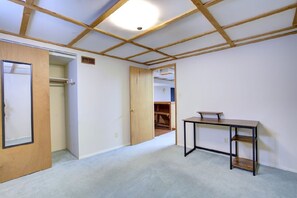 Cozy retreat with a closet, table, and ceiling with wooden beams.