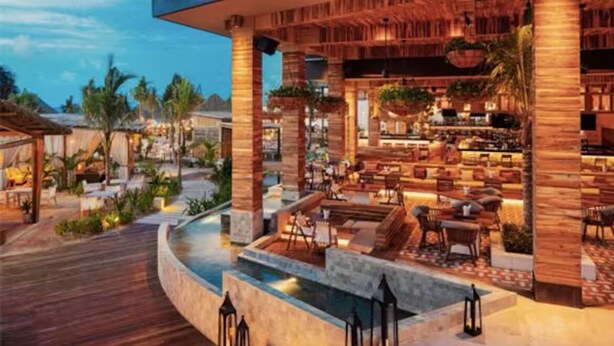 Un complexe hôtelier doté d’une piscine, d’un espace extérieur aménagé et d’un bar.